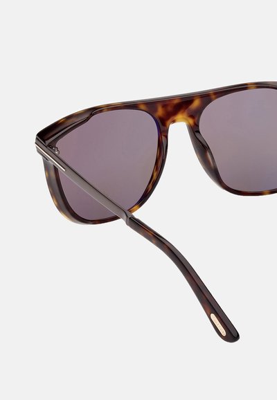 Tortoise-shell aurinkolasit tummilla linsseillä, joissa on tyylikäs metallikorostus otsalla ja kapea tempaukseen suunnittelu kiiltävällä pinnalla.
