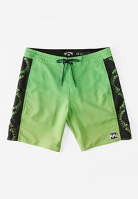 Shorts de bain verts avec des panneaux latéraux noirs ; avec une taille à cordon de serrage et un logo en motif répétitif sur les côtés.