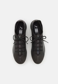 Scarpe da ginnastica nere con tessuto testurizzato, dotate di una punta liscia, design con lacci e accenti riflettenti scuri lungo i lati.