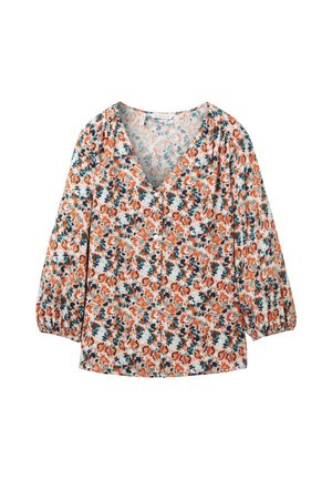 Blouse florale avec un col en V, des manches bouffantes longues, et un fond blanc orné de motifs orange et teal. Fabriquée en tissu léger.