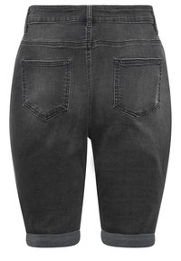 Pantalones cortos de mezclilla negra con dobladillo enrollado, bolsillos traseros y textura suave. La pretina está terminada con doble costura.