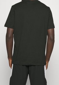 Zwarte katoenen t-shirt met een klassieke ronde hals, korte mouwen en een losse pasvorm, zonder opvallende patronen of accenten.