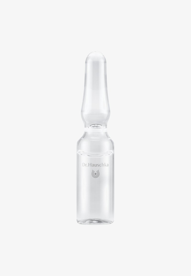 Petite ampoule en verre transparent à sommet arrondi, étiquetée "Dr. Hauschka", contenant un liquide transparent sur fond blanc.