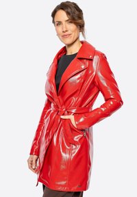 Červený, lesklý trench coat z umělé kůže s páskem v pase, klopovým límcem a bočními kapsami na zip. Přizpůsobený střih, dlouhé rukávy.