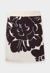 Stickad kjol med en krämfärgad bas och stora svarta blommönster, bred midjeband och rak silhuett.