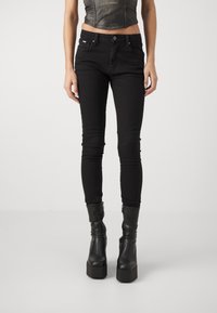 Jeans neri skinny in denim. Presentano un classico design a cinque tasche, zip frontale e una vestibilità slim con una consistenza liscia.