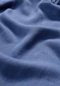 Blauwe stof met een gladde, gestructureerde afwerking, met een zachte val en een matte uitstraling, ideaal voor kleding of interieurtoepassingen.