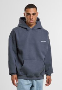 Dark gray hoodie with a front pocket, made of soft fabric. Features a v-neck design and a small "ANOTHER COTTON" logo in white.