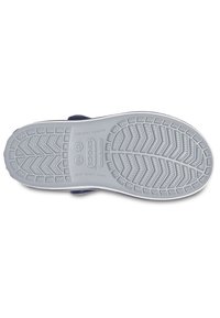 Bundvisning af en marineblå Crocs sko med en fleksibel grå ydersål og et mønster med tekstur for godt greb.