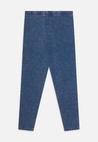 Tamsiai mėlyni džinsiniai leggingai, turintys lygų paviršių, elastingą juosmenį ir siaurą siluetą. Be kišenių ar matomų detalių.