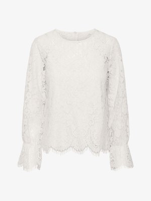 Valge pitsist top, millel on pikad varrukad, ümmargune kaelus, laineline äär koos frangeeritud servadega ning kogu pinna ulatuses lilleline pitsimuster.