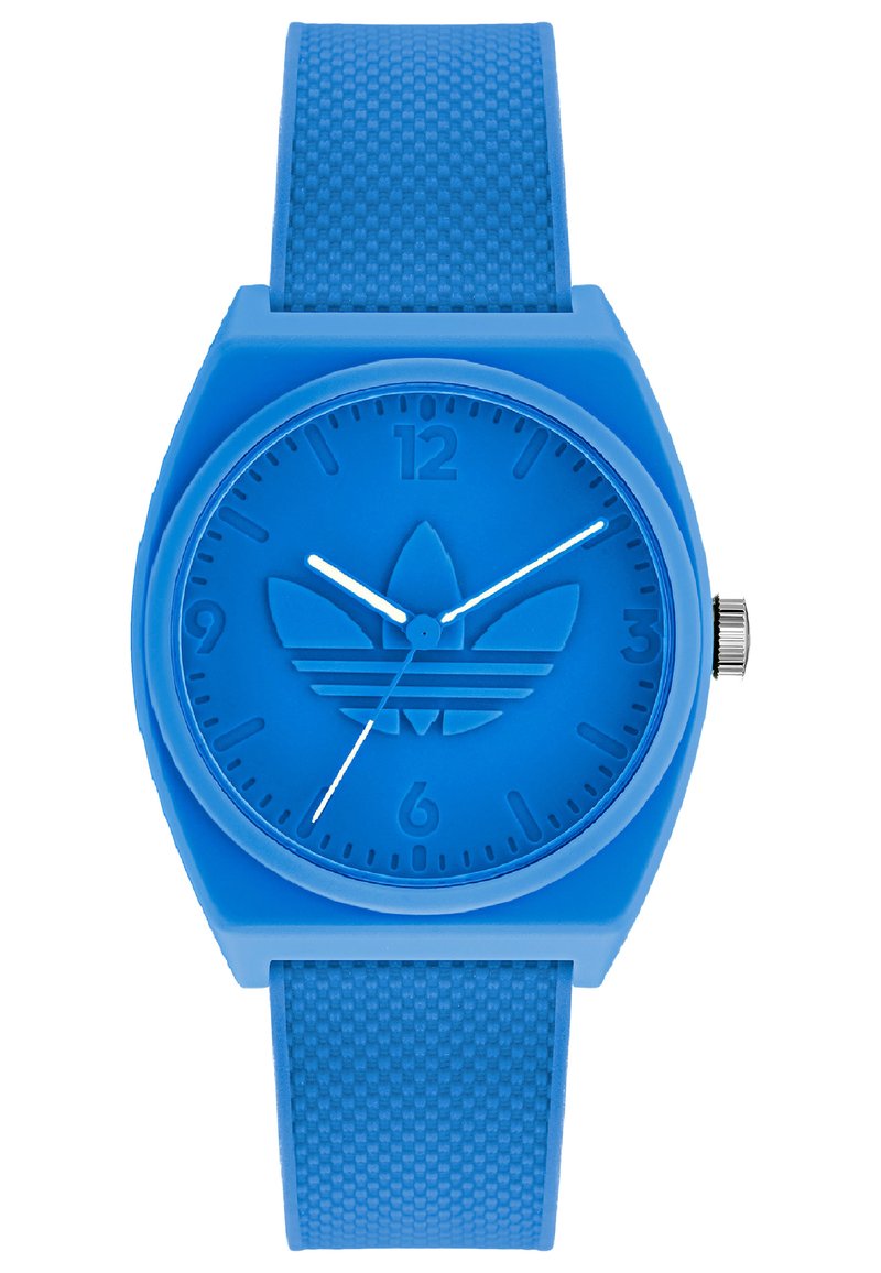 Montre en silicone bleue avec un bracelet texturé. Cadran rond, logo en relief, index horaires en relief et aiguilles des heures et des minutes blanches.