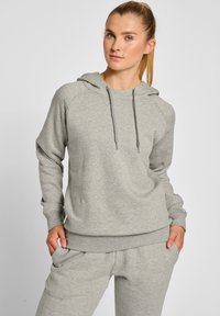 Ljusgrå hoodie med dragsko i huvan, ribbade muddar och midja. Mjuk material med avslappnad passform, i kombination med matchande joggerbyxor.