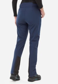 Pantalon de ski bleu marine avec une coupe droite, comportant des poignets zippés noirs et des jambes inférieures renforcées. Tissu lisse avec une texture durable.