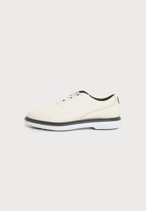 Chaussure décontractée blanche en cuir à lacets, avec doublure intérieure noire, bordure noire autour de la semelle et semelle extérieure en caoutchouc blanc vue de profil.