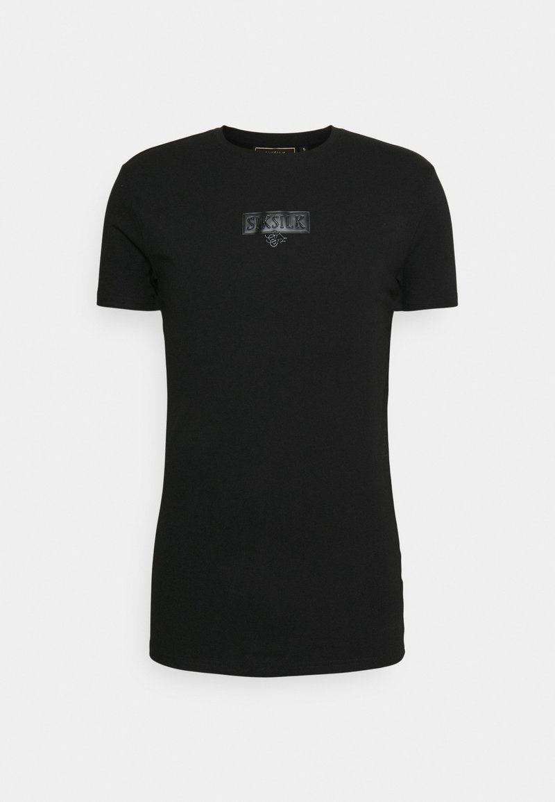 Camiseta negra de manga corta hecha de algodón, con un parche de logo texturizado en el centro. Cuello redondo, corte ajustado y textura suave.