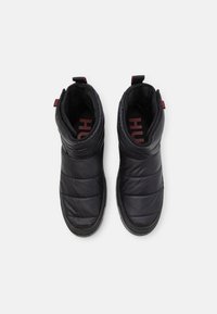 Botas de tobillo acolchadas negras con una textura suave, con una tirador en la parte posterior y suela de goma oscura. El interior presenta un logotipo rojo en la plantilla.