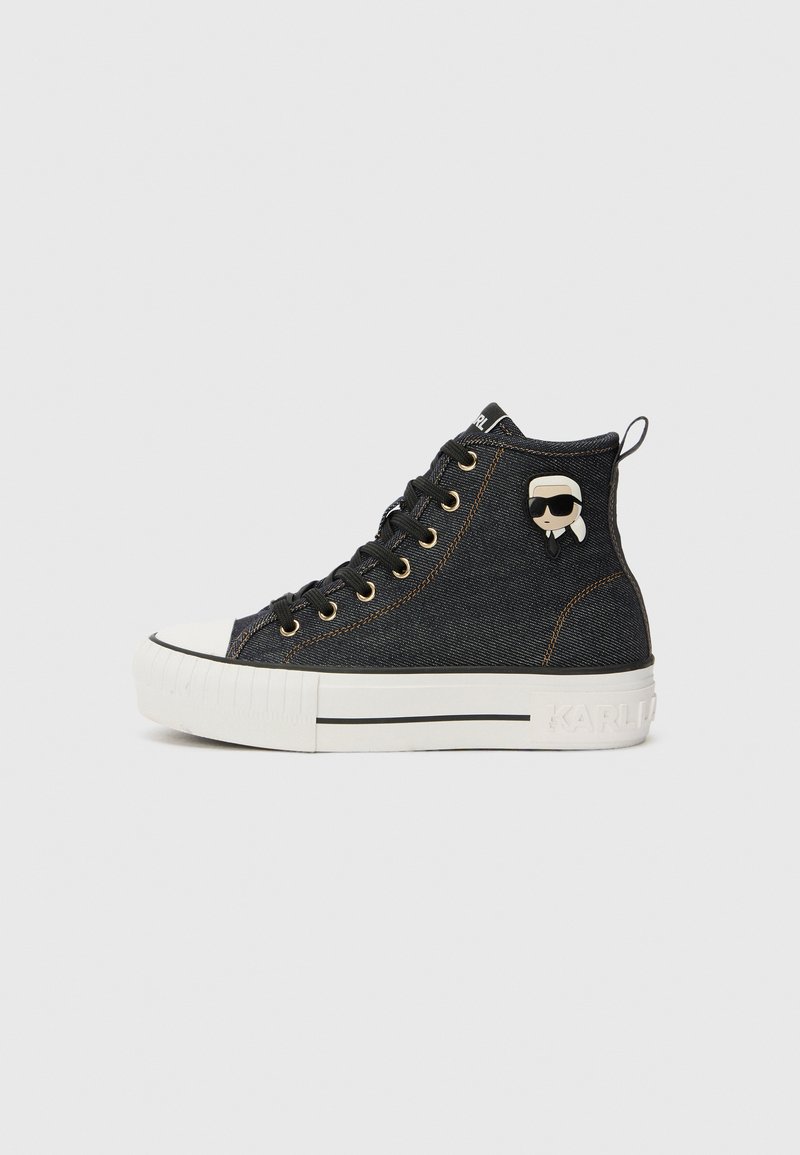 Sneaker alte in denim scuro con occhielli dorati. Presentano una punta bianca, una suola bianca a contrasto e un piccolo dettaglio di personaggio sul lato.