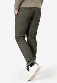 Graue strukturierte Hosen im schmalen Schnitt mit Seitentaschen und umgeschlagenem Saum. Kombiniert mit weißen Sneakern für einen lässigen Look.