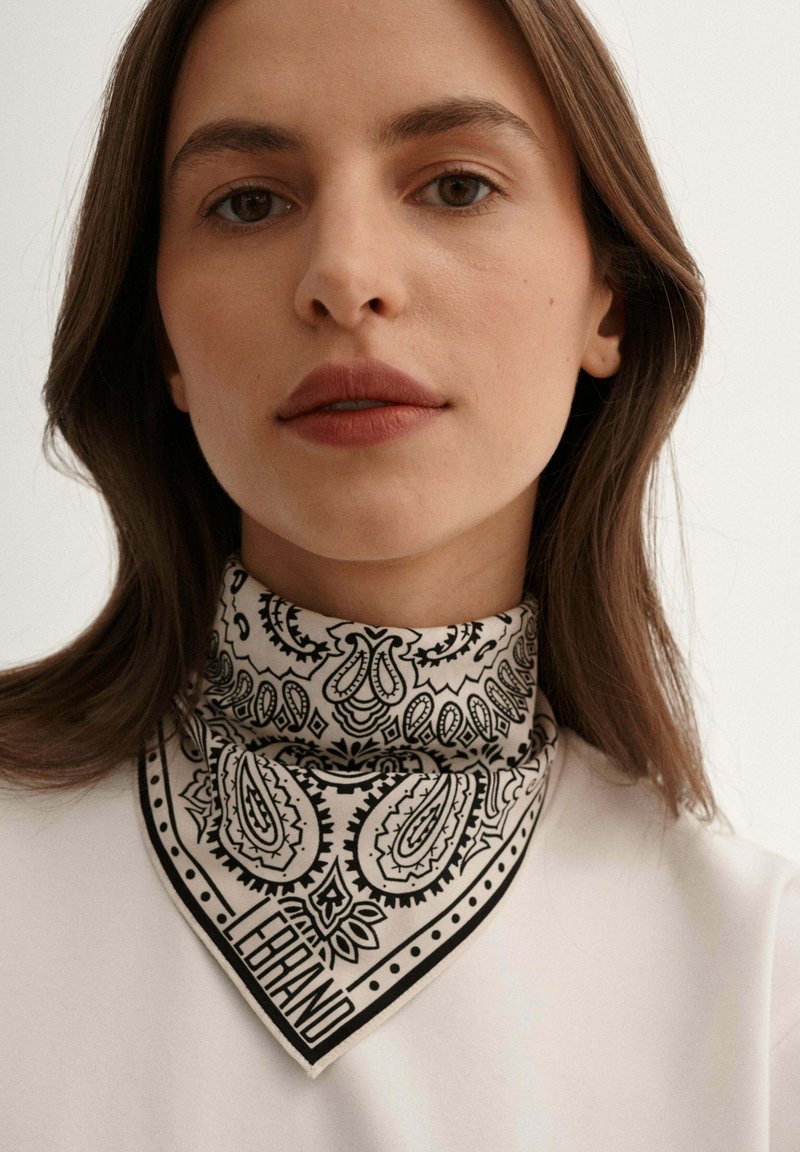 Czarnobiały szal w wzór paisley, wykonany z bawełny, w kształcie trójkąta, noszony na szyi, z napisem "LEBRAND" na dole.