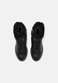 Black lace-up boots with a faux fur collar, featuring a smooth leather exterior, rounded toe, and metallic eyelets.