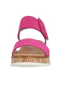 Różowe zamszowe sandały z dwiema szerokimi paskami i dekoracyjną klamrą. Posiadają naturalną korkową podeszwę oraz białą gumową spodnią część zapewniającą przyczepność.