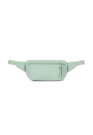Riñonera verde claro hecha de material suave, con un bolsillo con cremallera en la parte delantera, parche con logotipo y correas ajustables a cada lado.