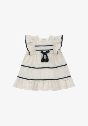 Vestido beige claro con mangas cortas con volantes, acentos a rayas de color navy y un dobladillo fruncido. Presenta un lazo decorativo y borlas en la parte delantera.