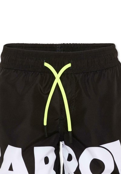 Shorts de bain noirs avec cordon de serrage jaune vif et grandes lettres blanches en gras partiellement visibles près du bas.