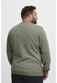 Grønn strikket genser, lange ermer, rund hals, teksturert stoff, tettsittende mansjetter og hem, med heathered mønster uten synlige logoer.