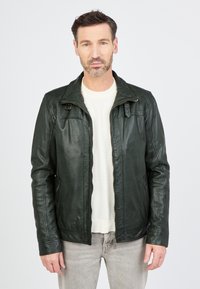 Donkergroene leren jas met een ritssluiting aan de voorkant, twee zijzakken en een kraagontwerp. De textuur lijkt soepel met een subtiele glans.