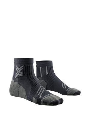 Paire de chaussettes de sport noires et grises aux chevilles avec talon et pointe renforcés, bord-côtes et détails de marque sur les côtés et les orteils.