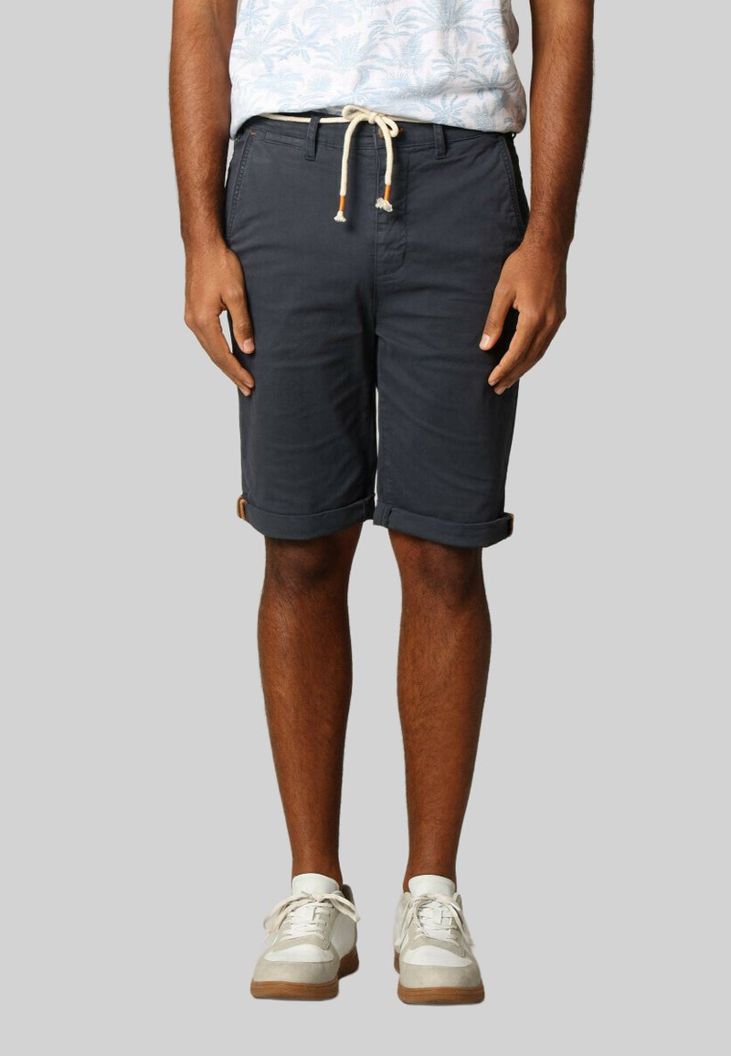 Heren shorts in donkergrijs met opgerolde zoom, van katoen, met zijzakken en een verstelbare tailleband. Gecombineerd met witte sneakers.