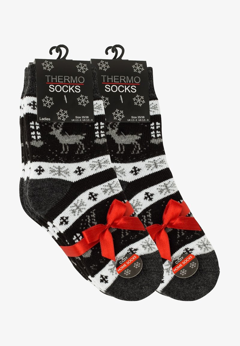 Schwarze und weiße Thermosocken mit einem Rentier-Muster und einem roten Ripsbandakzent am Bündchen. Das Material wirkt weich und warm.
