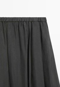 Jupe plissée gris foncé avec une taille élastique et un tissu léger, présentant une texture lisse et un éclat subtil.