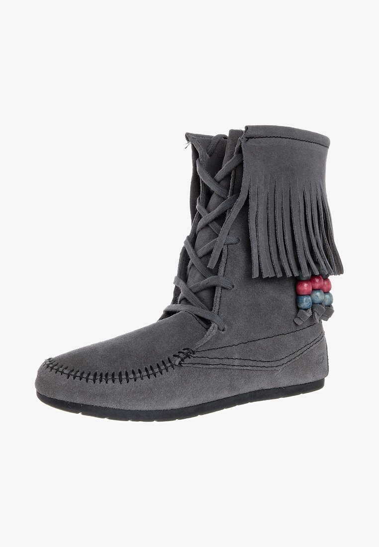 Grijze suède laars met franjes aan de bovenzijde, veters aan de voorkant, decoratieve kralenaccenten in rood en blauw, en een getextureerde zool.