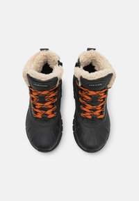 Bottes noires imperméables avec des lacets orange, doublure beige pelucheuse et semelles en caoutchouc texturé, affichant un logo sur le côté extérieur.