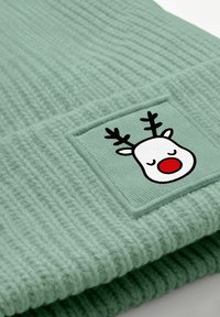 Mint green knit beanie featuring a rectangular patch with a cartoon reindeer face, red nose, and black antlers. Textured, ribbed design.