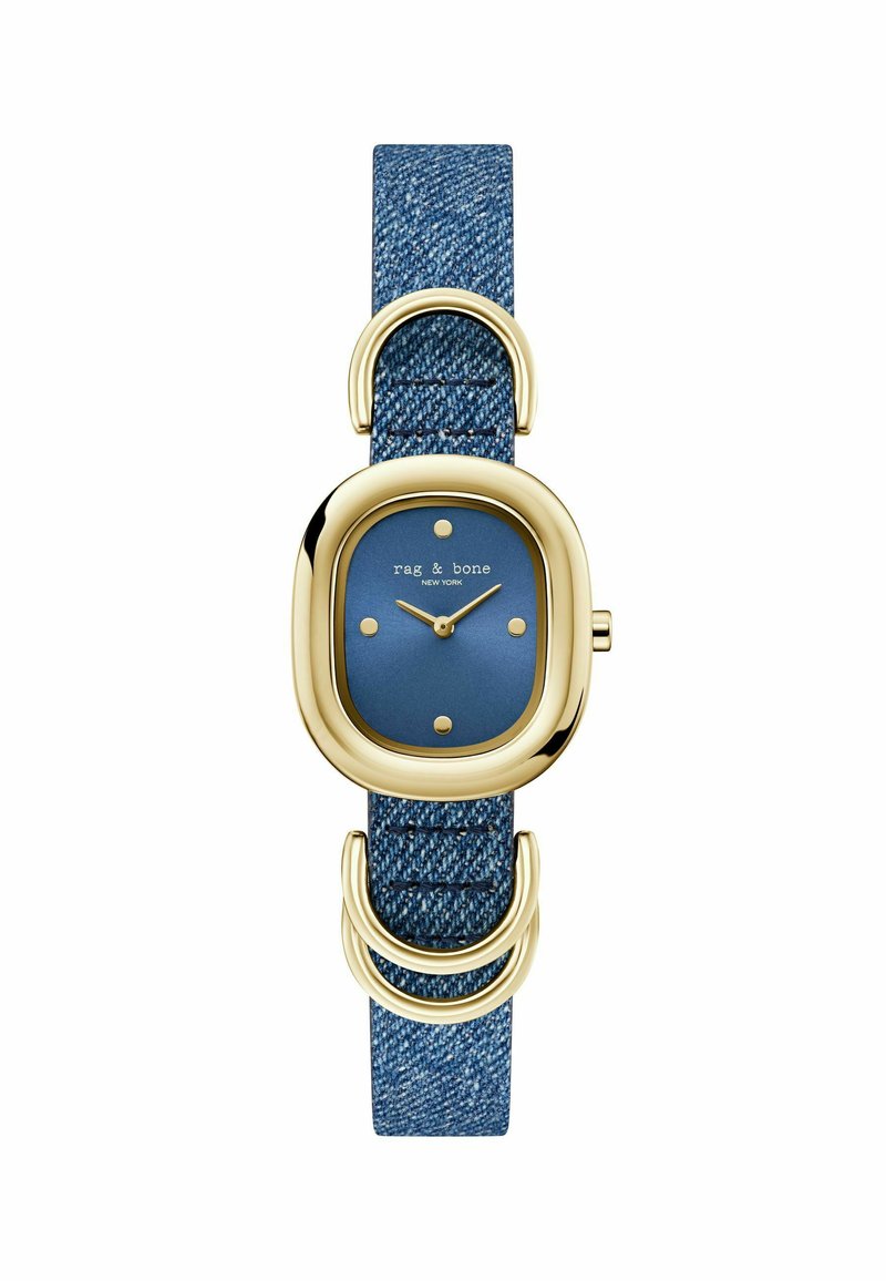 Kuldse tooniga kell, millel on ümar sinine sihverplaat, viis kuldset täpi tunni märkidena ja denimeerijaga rihm, millel on topelt-silmuse aktsendiga.