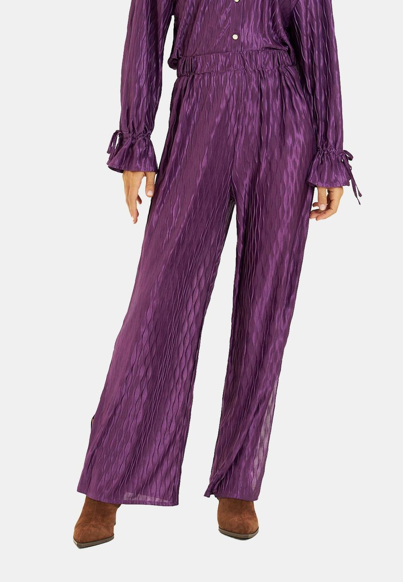 Fioletowe, fakturowane spodnie o szerokich nogawkach z wysokim stanem i elastycznym pasem, z prążkowanym wzorem i luźnym krojem, zestawione z dopasowanymi rękawami.