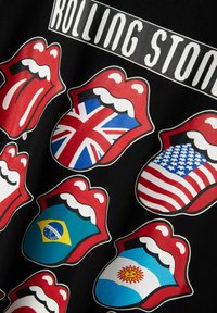 Sort T-shirt med røde læber og nationale flag: UK, USA, Brasilien, Argentina. Fed grafisk design med livlige farver og klare detaljer.