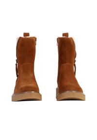 Stivaletti alla caviglia in suede marrone con zip laterale, rivestimento interno morbido e suola piatta in gomma. Il design presenta una linguetta sul retro.