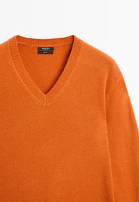 V-neck orange sweater made of 100% wool. Features ribbed neckline and cuffs, with a smooth texture and consistent color throughout.