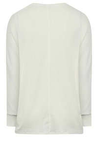 Světlé šedé tričko s dlouhými rukávy a texturovaným vzorem, kulatým výstřihem a rovnými lemy. Obsahuje žebrované akcenty na rukávech a po stranách.