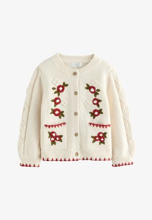 Cardigan in maglia color crema con ricamo floreale rosso e bianco, tasche frontali, bottoni marroni e bordi smerlati rossi su polsini e orlo.