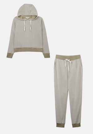 Felpa grigia chiara con cappuccio a cordino e pantaloni della tuta coordinati. Entrambi presentano polsini e vita verde oliva. Tessuto testurizzato, vestibilità comoda.