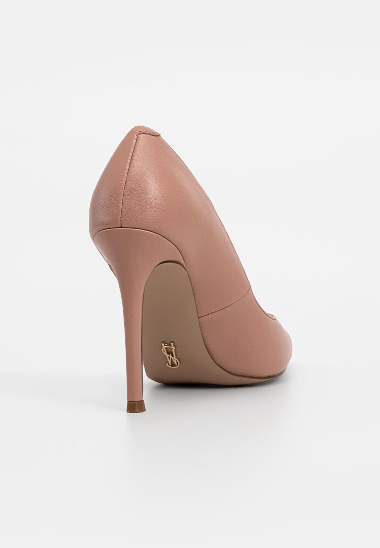 Chaussure à talon haut en cuir nude avec un bout pointu et un talon aiguille. Présente un subtil accent de logo doré à l'arrière. Texture lisse.