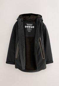 Crna jakna s kapuljačom i otvorenim prednjim dijelom koji otkriva mekanu flis podstavu, džepove sa patentnim zatvaračem sa strane i oznakom "Performance Edition" unutar ovratnika.