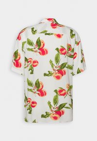 Camisa de manga corta con tela blanca y vibrantes estampados de hojas en color durazno y verde. Cuello con botones, corte relajado y textura suave.