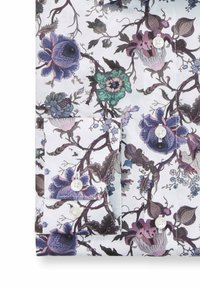 Kragenhemd mit weißem Hintergrund und einem mehrfarbigen Blumenmuster in Lila, Grün und Blau. Mit weißen Knöpfen und Detailtasche.